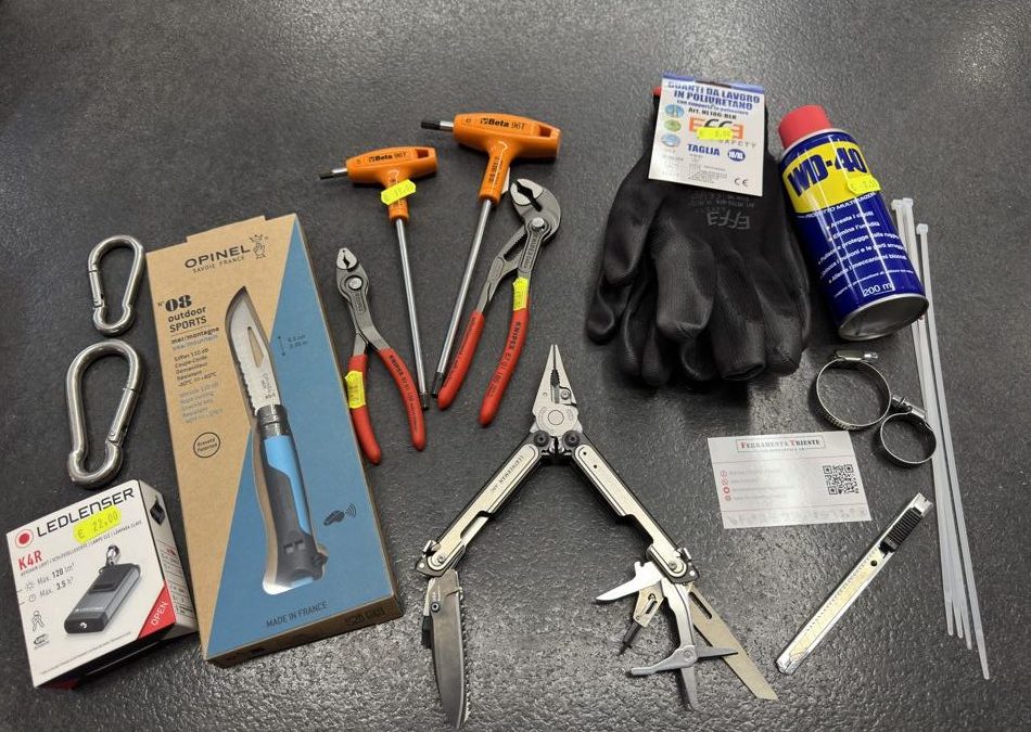Utensili, guanti, moschettoni inox, spray e multiuso Leatherman sul banco della Ferramenta Trieste