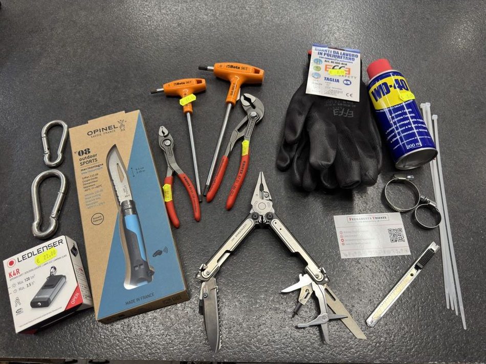 Utensili, guanti, moschettoni inox, spray e multiuso Leatherman sul banco della Ferramenta Trieste