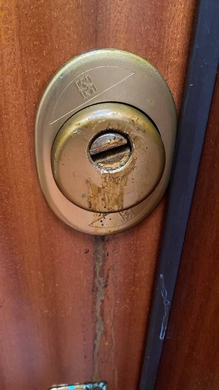 Cilindro di porta blindata danneggiato da acido, con colature sulla porta — intervento a Trieste