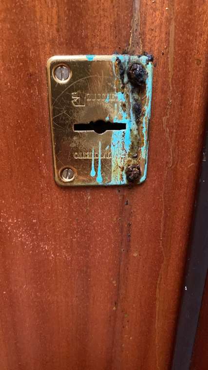 Placca della serratura corrosa dall’acido versato nel foro della chiave