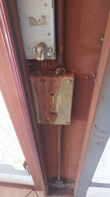 Serratura di porta blindata smontata: corrosione da acido su meccanismo e aste